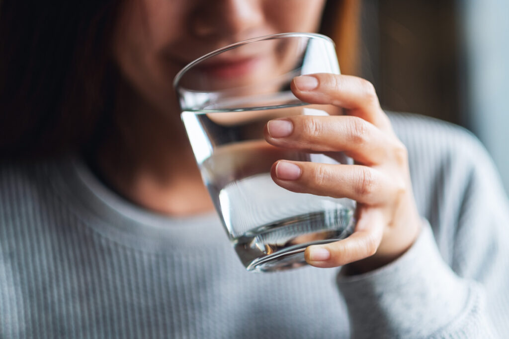 A person holding a glass of drinking water in Las Cruces.